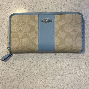 Coach long zipper wallet in tan signature pattern with light sky blue trim.